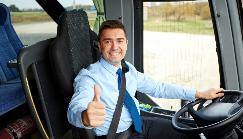 Man som sitter i en buss och är redo att köra iväg, han ger tummen upp.