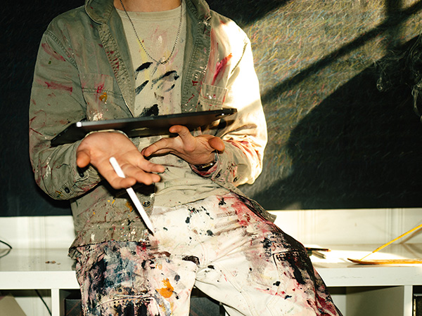 En målare som håller i en Ipad.