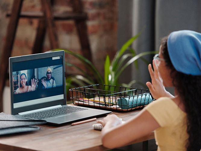 Kvinna som är virtuell assistent sitter vid en laptop och har möte.