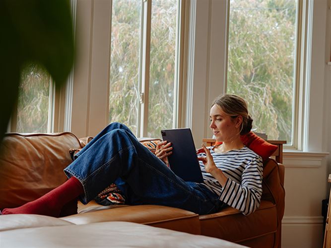 Kvinna i en soffa. Hon väljer mellan att fakturera utan företag eller starta eget.