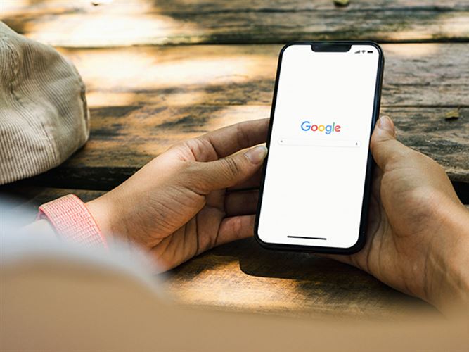 Hand med mobil som visar Google My Business.