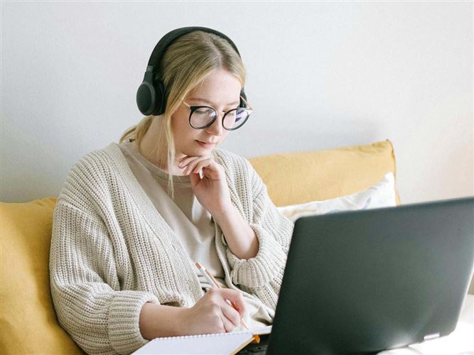 En företagare som sitter och jobbar framför en laptop. Ska föreställa digitalisering av företag.
