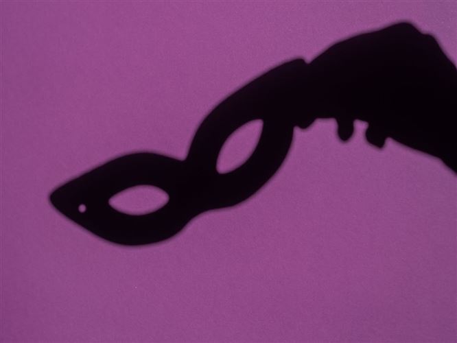 Skugga av en hand som håller en ögonmask för att representera affärsförhandling.