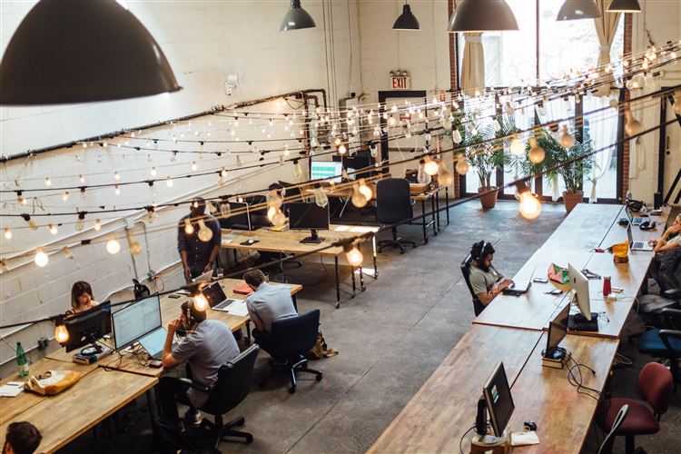Ett coworking space där många människor sitter och jobbar.